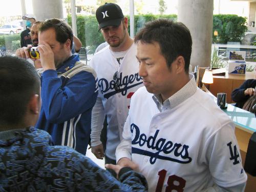 ロサンゼルス郊外の病院でファンと握手するドジャースの黒田。奥はペニー