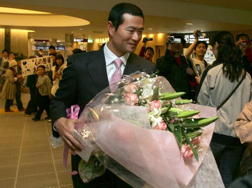 会見を終えファンからもらった花束を手に空港を後にする桑田