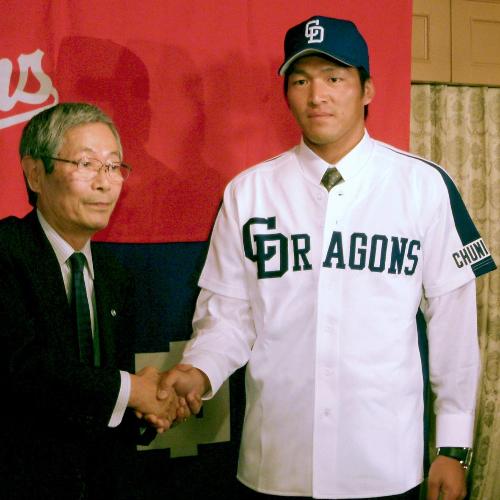 横浜から中日に移籍、入団会見で伊藤一正球団代表と握手する小池正晃外野手