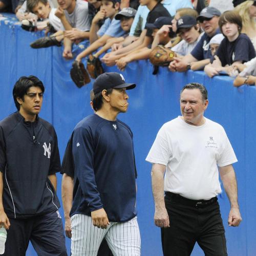 試合前にトレーナー（右）からランニングのチェックを受け、引き揚げるヤンキースの松井秀