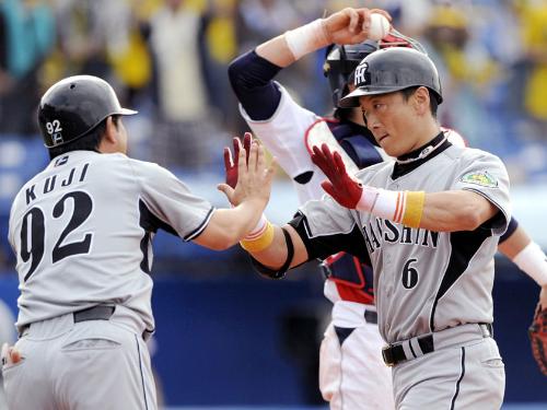 ８回、通算４５０号本塁打を放ち久慈コーチ（左）に迎えられる阪神・金本