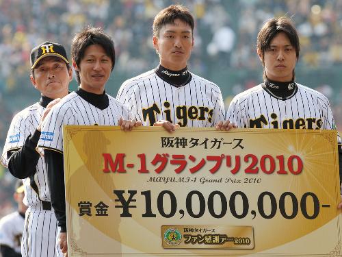 Ｍ－１グランプリに選ばれ、真弓監督（左）から賞金１０００万円を受け取った藤川俊（左から２人目）、秋山（同３人目）、西村（右）