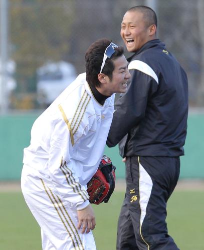 ノックのボールが足に当たり痛がる西岡（左）と、笑顔を見せる中田