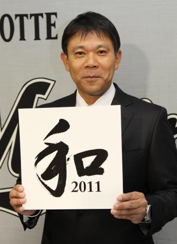 今季のチームスローガン「和２０１１」の色紙を持つ西村監督