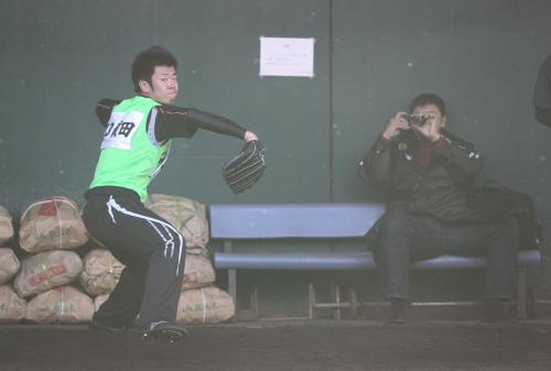 ＜阪神・新人自主トレ＞藪２軍投手コーチ（右）が写真を撮る中、初ブルペンで力投する榎田