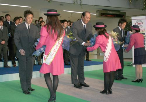 宮崎空港に到着し、セレモニーで花束を受け取る西武の渡辺監督（中央）ら