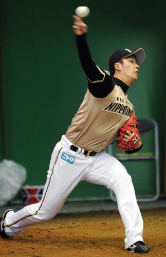 ブルペンで投球練習する日本ハム・斎藤