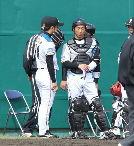 ＜日本ハム・韓国サムスン＞登板前に捕手の鶴岡（右）が斎藤とサインの打ち合わせをする