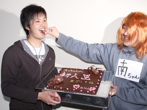 大石（左）は、記者が扮した人気漫画タッチの南ちゃんにチョコをプレゼントされ食べさせてもらう