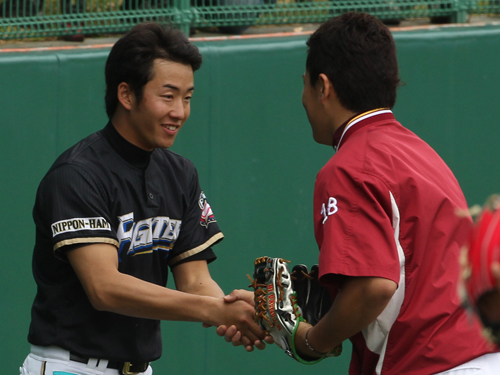 再会の握手を交わす田中（右）と斎藤