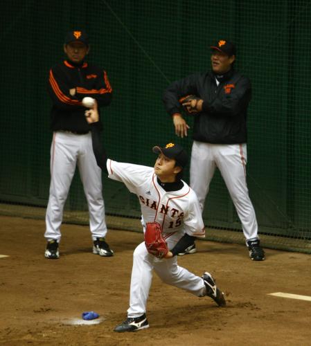 川口、斎藤両コーチ（左、右）の前で投球練習する沢村