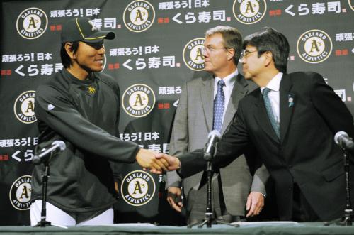 在サンフランシスコ日本総領事館の猪俣弘司総領事（右）と握手するアスレチックスの松井秀喜外野手。中央はクロウリー球団社長