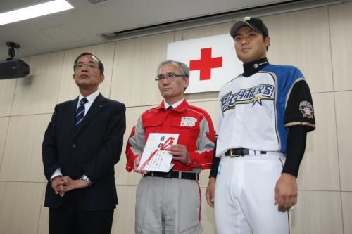 義援金の寄託式で写真撮影に応じる（左から）津田球団社長、日本赤十字社北海道支部の中島事務局長、田中