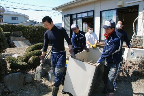 津波で浸水した住宅から家具を運び出す、東北高校野球部員