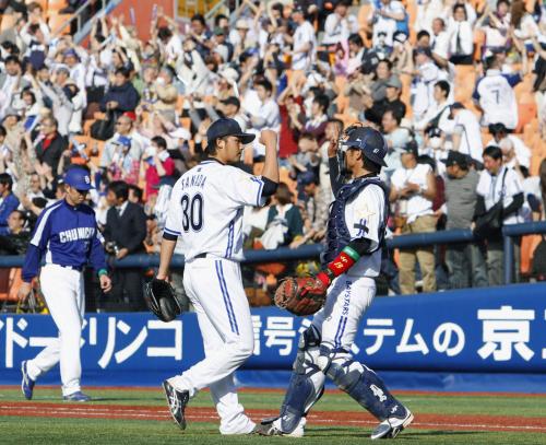 ９回、最後の打者を打ち取り開幕カード勝ち越しを決め、タッチを交わす横浜・真田（30）と捕手武山