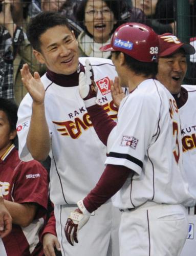 １回、先頭打者本塁打を放った松井稼（手前）を笑顔で迎える楽天・田中