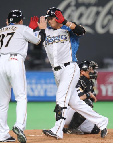 ５回、先制本塁打を放ち迎えられる日本ハム・中田。捕手細川