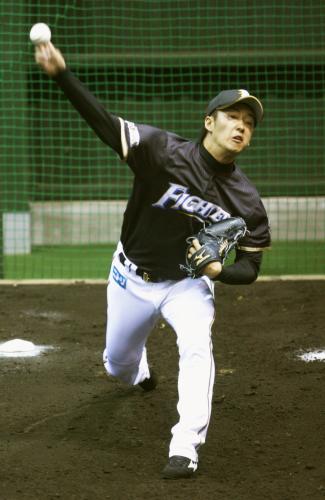 ブルペンで捕手を座らせて投球する日本ハム・斎藤