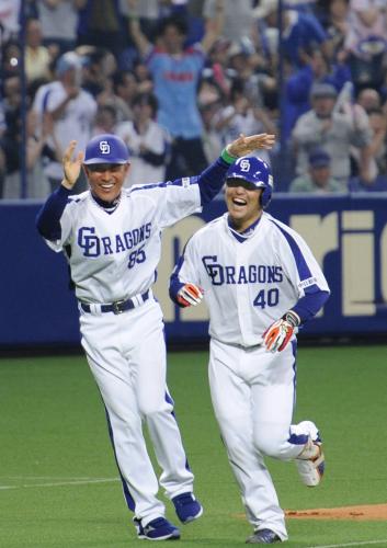 ９回、２戦連続のサヨナラ本塁打を放ち三塁の辻コーチ（左）と喜ぶ中日・平田