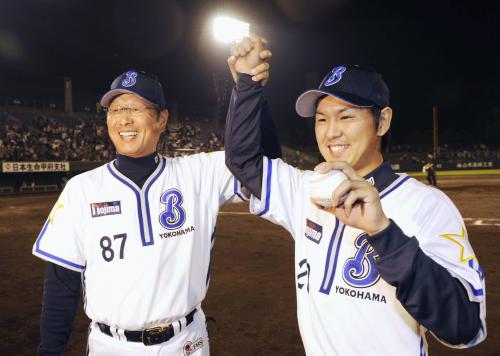 プロ初勝利を挙げ、ウイニングボールを手に尾花監督（左）と喜ぶ横浜・須田
