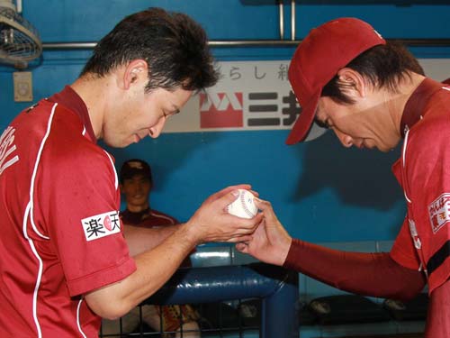 ＜ロ・楽＞１０００試合出場の高須（左）は永井からウイニングボールを最敬礼して受け取る