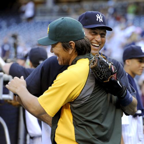 試合前、ヤンキースのジーター（右）と抱き合うアスレチックス・松井