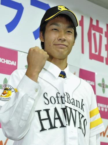 １位指名を受けたソフトバンクのユニホームを着てガッツポーズする宮崎日大高の武田翔太投手