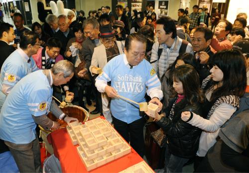 プロ野球ソフトバンクの日本一を祝した優勝セールを前に、振る舞い酒に集まる買い物客ら