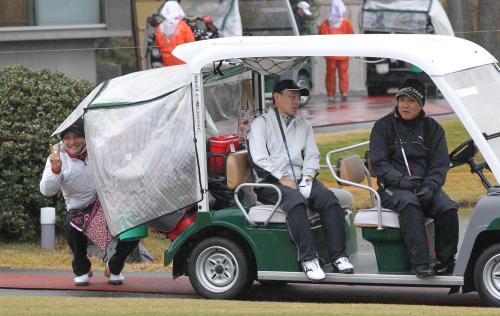 納会ゴルフのプレー中、雨宿りしながら山岸均球団取締役（中央）と話す原監督。その横で沢村は陰に隠れてカメラにピース