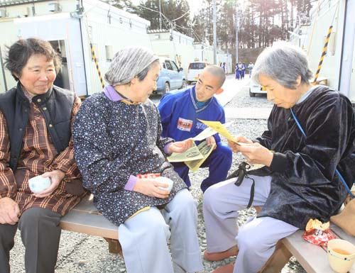 ボランティア活動の一環で仮設住宅の住民たちに話しかける浦田
