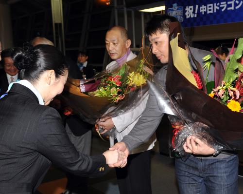 Ｖ旅行出発式で花束を贈られる森野選手会長と落合前監督（右から）