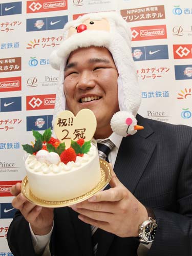 ３年１０億円で更改した中村は、サンタの帽子をかぶり２冠のケーキを手に笑顔