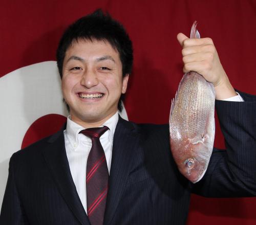 ５２００万円で契約を更改した沢村は鯛を手に笑顔を見せる