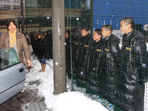 母校訪問を終えた松井（左）は、雪の降りしきる中でサッカー部の生徒に見送られて笑顔