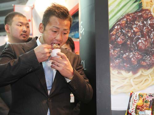 日本ハムグループの商品展示会でビビンバを試食する日本ハム・中田