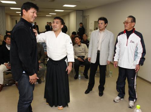 藪コーチ（左）に姿勢を伝授する藤平氏（同２人目）。和田監督（同３人目）と広岡氏も観察