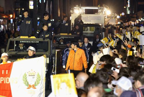 パレードで市民の歓迎を受ける秋山監督（先頭車両の左）らソフトバンクナイン