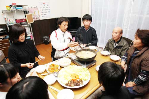 福島県浪江町から宮崎市で避難生活をする佐藤さん一家とあんこう鍋を囲む巨人・鈴木（中央）