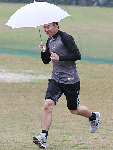 雨の中、傘をさして移動する斎藤