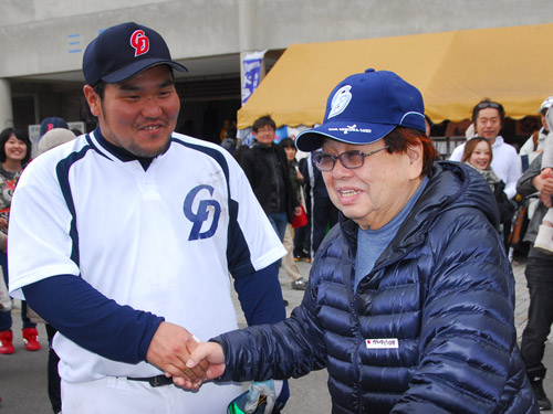 中日キャンプを訪問した高木ブー（右）と笑顔で握手を交わす中田亮