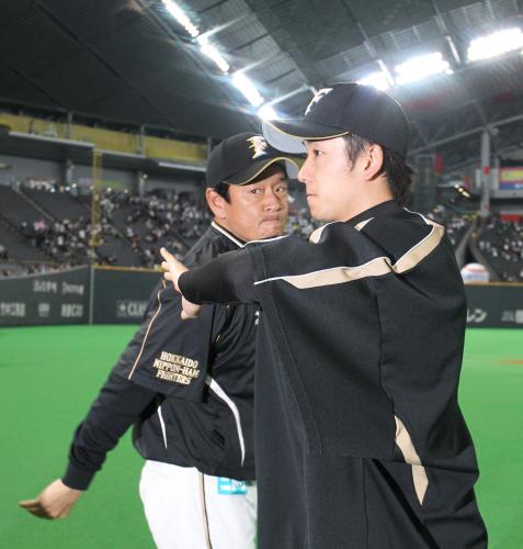 ＜日・ソ＞試合後、こわばった表情で栗山監督（左）とハイタッチをする斎藤
