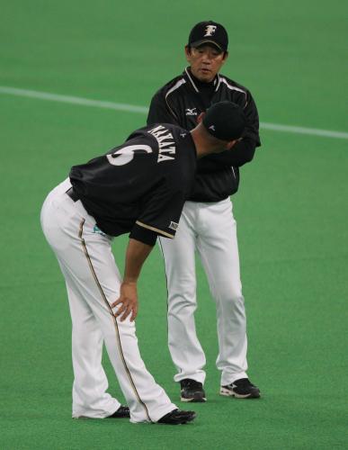 右膝を痛めた中田（左）に話しかける日本ハム・栗山監督