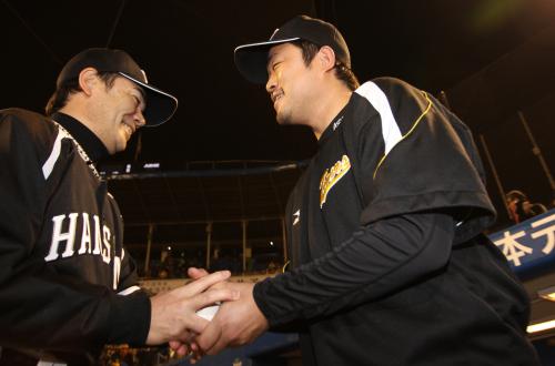 ＜ヤ・神＞ウイニングボールを手に、和田監督（左）と笑顔で握手をかわす安藤