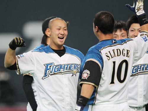 ＜日・楽＞９回、サヨナラ本塁打を放ち、スレッジ（右）と日本ハム・中田は“勝利のタッチ”