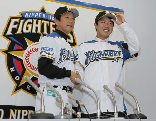 阪神から交換トレードで日本ハムに移籍し、栗山監督（左）と笑顔で握手する若竹竜士投手