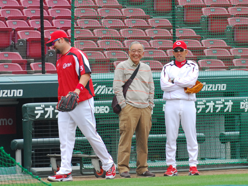 練習中のグラウンドに現れ、野村監督（右）と談笑する松田オーナー（中）