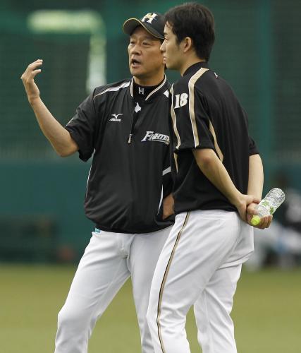 ＜西・日＞試合前、斎藤（右）と言葉をかわす日本ハム・栗山監督