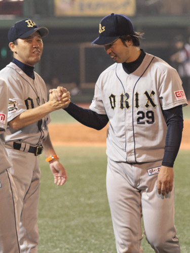 日本球界復帰後初勝利を挙げ、岡田監督（左）から祝福される井川