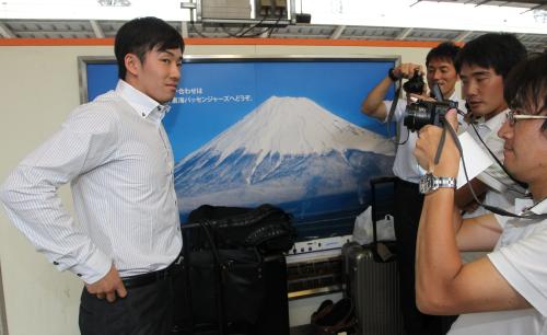 日本ハム・斎藤が東京駅のホームの富士山のポスターの前で、報道陣にカメラを向けられる