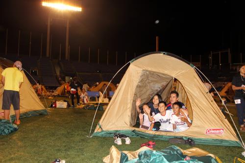 神宮球場のグランドにテントを張りスタジアムキャンプを行う家族